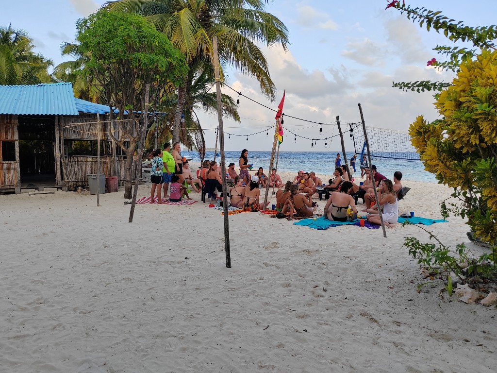 Grupo de viajeros compartiendo al atardecer en la playa